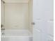 Bathroom bathtub and tile surround next to a white interior door at 9461 Elmhurst Ln # C, Highlands Ranch, CO 80129