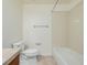 Neutral toned bathroom with tiled floors and walls, bathtub and shower, and white toilet at 9461 Elmhurst Ln # C, Highlands Ranch, CO 80129