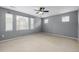Spacious bedroom featuring carpeted floors, neutral walls, a ceiling fan, and lots of natural light at 9461 Elmhurst Ln # C, Highlands Ranch, CO 80129