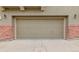 Garage door with neutral siding and brick accents on either side provide curb appeal at 9461 Elmhurst Ln # C, Highlands Ranch, CO 80129
