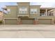 Three garages offer ample parking with modern doors and brick accents on a gray building at 9461 Elmhurst Ln # C, Highlands Ranch, CO 80129