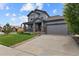 Beautiful gray home with a welcoming front porch and two-car garage, complemented by a green lawn at 8182 Grady Cir, Castle Rock, CO 80108