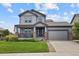 Charming gray two-story home featuring a covered front porch, stone accents, and a well-manicured lawn at 8182 Grady Cir, Castle Rock, CO 80108