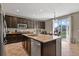 Modern kitchen featuring dark wood cabinets, an island, stainless steel appliances, and tile flooring at 8182 Grady Cir, Castle Rock, CO 80108