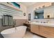 Relaxing bathroom featuring soaking tub, modern fixtures, and stylish vanity with marble backsplash at 3632 N Pecos St, Denver, CO 80211