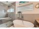 Modern bathroom featuring a soaking tub, glass-enclosed shower, and neutral tile at 3632 N Pecos St, Denver, CO 80211