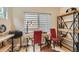 This home office features a wooden desk, shelves, red chairs, and lots of natural light from a window at 3632 N Pecos St, Denver, CO 80211