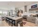 Open concept kitchen with an island, stainless steel appliances, breakfast bar, and decorative lighting at 3632 N Pecos St, Denver, CO 80211