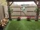 Cozy backyard featuring wood cart, artificial turf, potted plants, and decorative gate at 7925 W Layton Ave # 322, Littleton, CO 80123