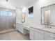 A stylish bathroom with double sinks, quartz countertops, a vanity area, and a glass-enclosed shower at 928 Farrier Ln, Lafayette, CO 80026