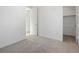 Bright bedroom featuring neutral carpet, white walls, closet, and a door, creating a minimalist yet inviting space at 928 Farrier Ln, Lafayette, CO 80026
