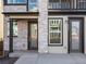 Home entry featuring stone facade with grey door, window, and house number at 928 Farrier Ln, Lafayette, CO 80026