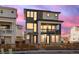 Stunning two-story home with a stone facade, second story balcony, and beautiful landscaping, at sunset at 928 Farrier Ln, Lafayette, CO 80026