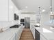 Bright kitchen featuring stainless steel appliances and fixtures, sleek white cabinets, and quartz countertops at 928 Farrier Ln, Lafayette, CO 80026