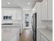 Spacious kitchen with stainless steel appliances, white cabinetry, a gas cooktop, and quartz countertops at 928 Farrier Ln, Lafayette, CO 80026
