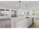 Open-concept kitchen with stainless steel appliances, white cabinetry, quartz countertops, and a view of the balcony at 928 Farrier Ln, Lafayette, CO 80026