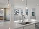 Modern kitchen featuring stainless steel faucet, sliding glass doors, and quartz countertops at 928 Farrier Ln, Lafayette, CO 80026