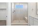 Bright bathroom featuring a glass-enclosed shower with tiled walls, a built-in seat, and a window at 928 Farrier Ln, Lafayette, CO 80026