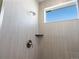 Modern tiled shower featuring a rainfall showerhead, a built-in shelf, and a window at 928 Farrier Ln, Lafayette, CO 80026