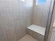 Tiled shower with a built-in seat and a window for natural light at 928 Farrier Ln, Lafayette, CO 80026