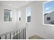 A staircase featuring white risers and black iron railings, bathed in natural light from multiple windows at 928 Farrier Ln, Lafayette, CO 80026