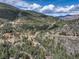 Expansive view of mountainside community surrounded by lush trees under partly cloudy skies at 1353 Elk Valley Dr, Evergreen, CO 80439