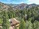 Serene aerial view of a mountain home surrounded by lush green trees with mountain views at 1353 Elk Valley Dr, Evergreen, CO 80439