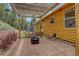 Private backyard featuring a covered patio, a fire pit, and comfortable outdoor seating with lush green trees at 1353 Elk Valley Dr, Evergreen, CO 80439