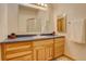 Bright bathroom with a modern sink, wood cabinets, a large mirror and a glass-enclosed shower at 1353 Elk Valley Dr, Evergreen, CO 80439