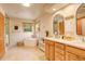Bright bathroom featuring double vanities, a soaking tub, and wood-trimmed windows, offering a spa-like retreat at 1353 Elk Valley Dr, Evergreen, CO 80439