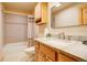 Well-lit bathroom featuring a marble countertop, wood cabinets, and a bathtub/shower combination at 1353 Elk Valley Dr, Evergreen, CO 80439