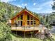 Charming cabin with large windows and a spacious deck, perfect for enjoying the mountain views at 1353 Elk Valley Dr, Evergreen, CO 80439