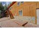 Exterior view of the back of the house, featuring a patio and wooden staircase at 1353 Elk Valley Dr, Evergreen, CO 80439