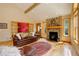 Comfortable living room with a stone fireplace, hardwood floors, and a leather sofa, creating a warm atmosphere at 1353 Elk Valley Dr, Evergreen, CO 80439