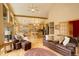 Open-concept living space with kitchen bar, dining area, and exposed ceiling beams for rustic charm at 1353 Elk Valley Dr, Evergreen, CO 80439