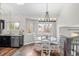 Dining area with a modern chandelier, white table set, hardwood floors, and lots of natural light at 11402 Benton Ct, Westminster, CO 80020