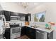 Modern kitchen with black cabinets, granite countertops, stainless steel appliances, and hardwood floors at 11402 Benton Ct, Westminster, CO 80020