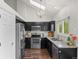 Modern kitchen with black cabinets, granite countertops, stainless steel appliances, and hardwood floors at 11402 Benton Ct, Westminster, CO 80020