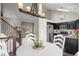 Open-concept kitchen and dining area with stainless steel appliances, black cabinets, and hardwood floors at 11402 Benton Ct, Westminster, CO 80020