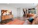 Open-concept living area featuring wood floors, large dresser, and access to the kitchen and stairs at 11402 Benton Ct, Westminster, CO 80020