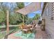 Outdoor patio with a wooden dining set under a shaded canopy at 1171 Syracuse St, Denver, CO 80220