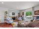Comfortable living room featuring a stone fireplace, hardwood floors, and a large window at 4194 S Kalispell St, Aurora, CO 80013