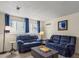 Cozy living room with comfortable blue sofas, neutral walls, and a bright window with blue curtains at 4194 S Kalispell St, Aurora, CO 80013