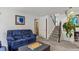 A living room showcases a plush blue sofa, a staircase, and neutral carpeting at 4194 S Kalispell St, Aurora, CO 80013