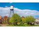 Scenic view of a community park featuring mature trees and a prominent water tower at 5465 Zephyr St # 201, Arvada, CO 80002