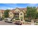 Two-story condo complex with lush green landscaping, a convenient staircase, and parking spaces at 5465 Zephyr St # 201, Arvada, CO 80002