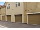 Attached garages for condo units featuring dark doors and street-level access for residents at 5465 Zephyr St # 201, Arvada, CO 80002