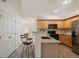 Modern kitchen featuring stainless steel appliances, bar seating, and wood-look floors at 5465 Zephyr St # 201, Arvada, CO 80002