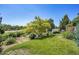 View of the beautifully landscaped backyard featuring mature trees and a privacy fence at 428 Starline Ave, Lafayette, CO 80026