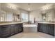 Luxurious bathroom with dual vanities, a soaking tub, tiled backsplash, and modern fixtures at 428 Starline Ave, Lafayette, CO 80026